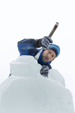 Heykeltıraş Noel için buz kalıbından bir buz heykeli kesiyor.