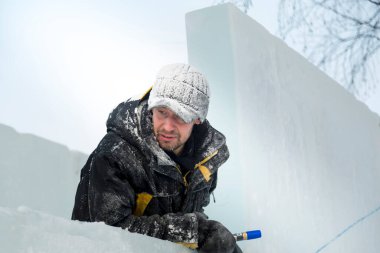 Kış tulumlu bir ustanın portresi. Buz panelinde elinde bir işaret var.