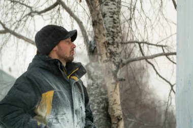 İş yerinde siyah kış şapkası takan işçi derleyicilerin yakın çekimi.