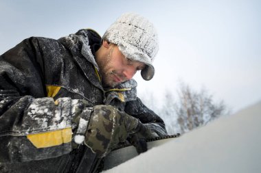 Elle çalışan biri elektrikli testere keskinleştirir.