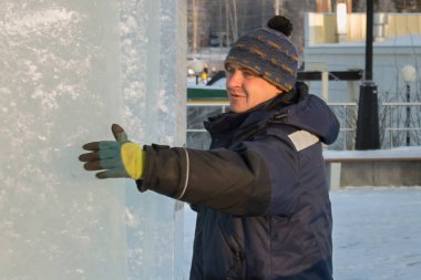 Mavi ceketli Slinger derleyicisi buz panellerini boşaltıyor.