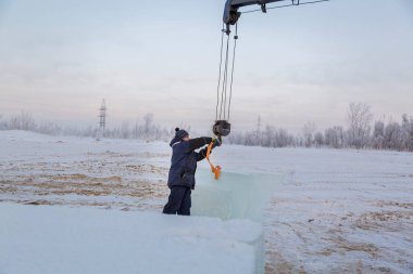 Slinger yükleyici kancaya bir bant halatı takar.