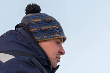 İş yerinde mavi kışlık ceketli bir adamın portresi.