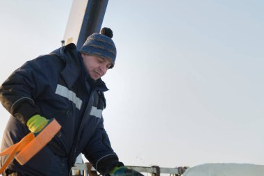 Elinde kurdele askısıyla mavi ceketli bir işçinin portresi.