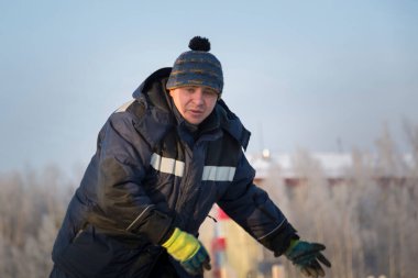 İş yerinde mavi kışlık ceketli bir adamın portresi.