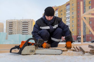 İşçi derleyici bir mezura ile tahtayı işaretler