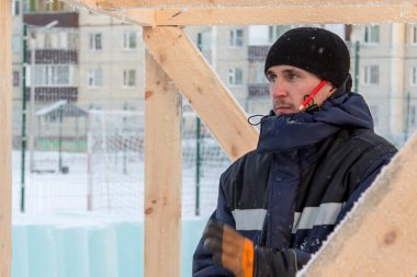 İşyerindeki erkek işçinin kulağının arkasındaki kırmızı kalemle yakın plan portresi.