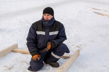 İş yerinde mavi kışlık ceketli bir adamın portresi.