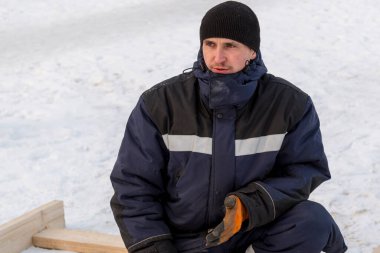 İş yerinde mavi kışlık ceketli bir adamın portresi.