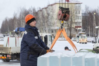 Turuncu bir miğferde buz döken bir askının portresi.