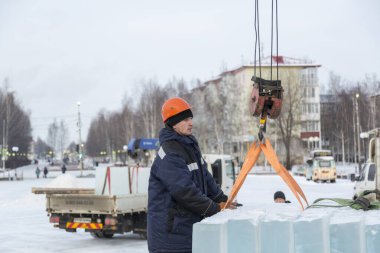 Turuncu bir miğferde buz döken bir askının portresi.
