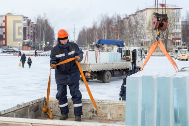 Turuncu bir miğferde buz döken bir askının portresi.