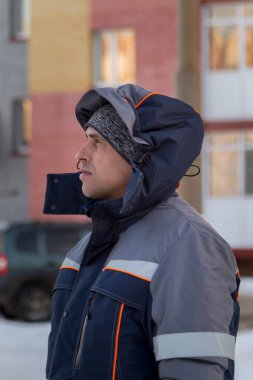 Başında kapüşonlu koruyucu iş elbisesi olan bir işçinin portresi.