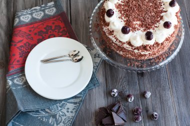 Kara Orman kek krem şanti ve kirazı ile dekore edilmiş.