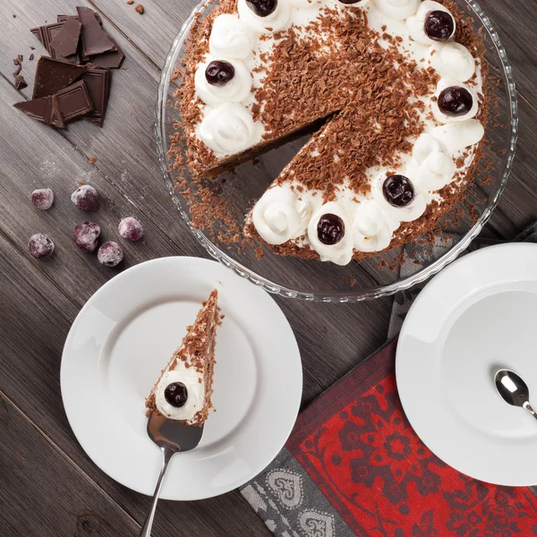 Black forest cake decorated with whipped cream and cherries.