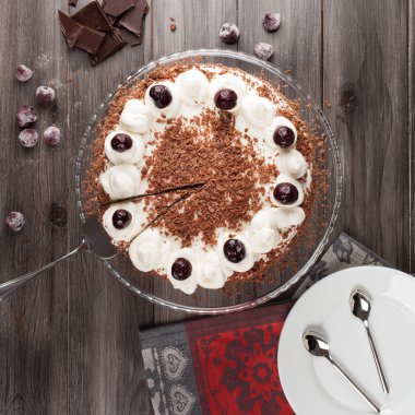 Kara Orman kek krem şanti ve kirazı ile dekore edilmiş.