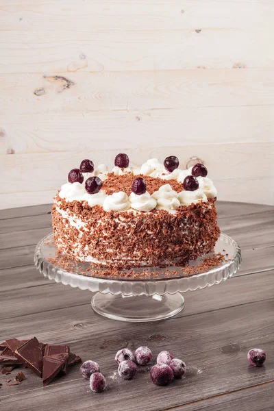 Black forest cake decorated with whipped cream and cherries.