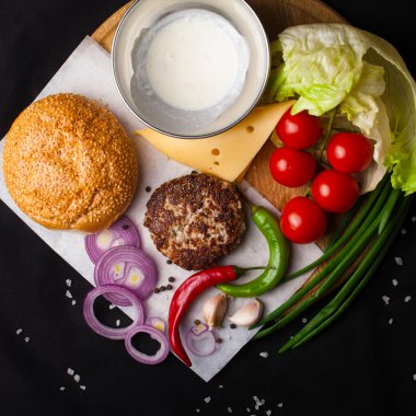 Karanlık bir arka plan üzerinde hamburger için malzemeler. Üstten Görünüm.