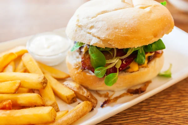 Hamburger with fresh vegetables and French fries. — Stock Photo, Image