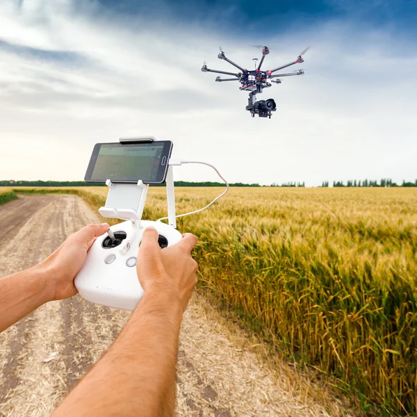 Bezpilotní vrtulník. Muž řídí quadrocopter letu. — Stock fotografie