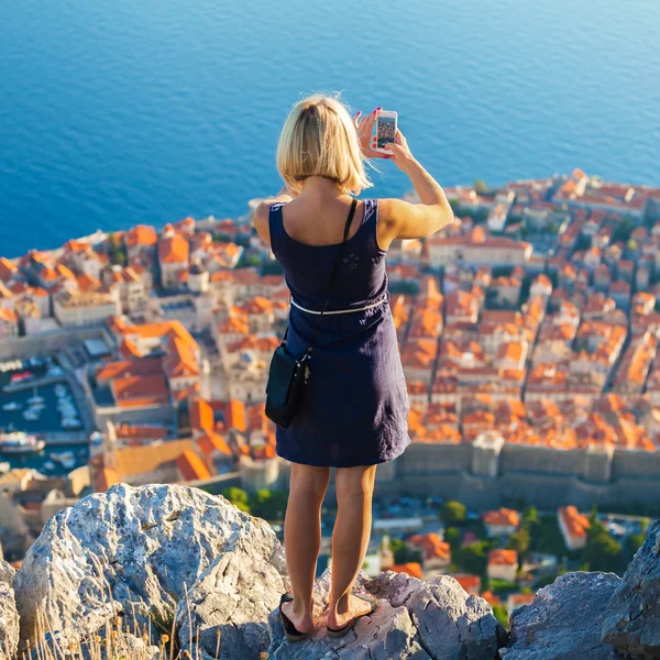 Kvinnliga resenär göra ett foto av Dubrovnik till telefonen. — Stockfoto