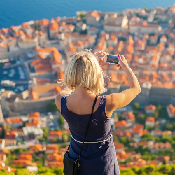Female traveller make a photo of Dubrovnik to the phone. — Stock Photo, Image