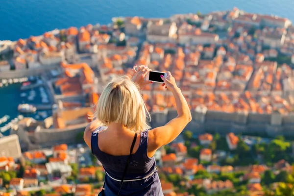 Mujer viajera hacer una foto de Dubrovnik al teléfono . — Foto de Stock
