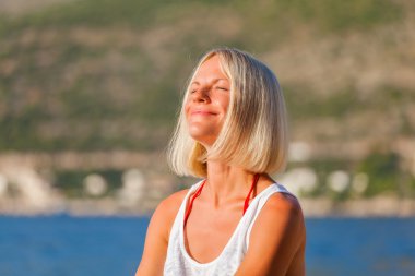 Hırvatistan'daki plajda sarışın kız sunbathes.