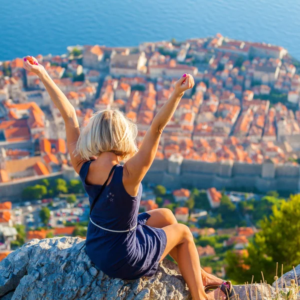 Mujer joven turista mira a la ciudad vieja de Dubrovnik . — Foto de Stock