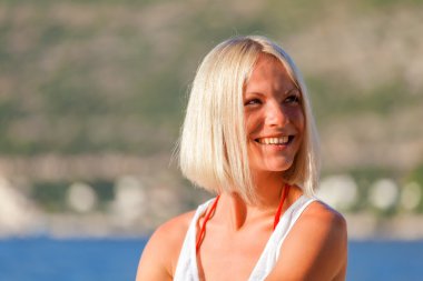 Hırvatistan'daki plajda sarışın kız sunbathes.