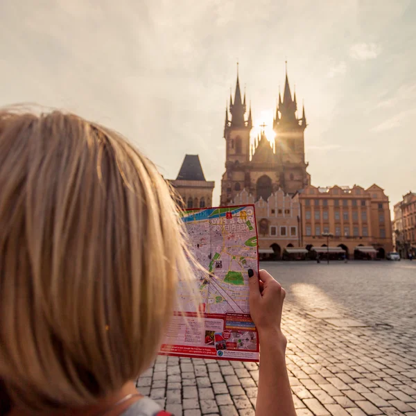 Krásná mladá dívka v Praze se dívá na mapa města. — Stock fotografie