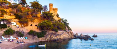 Bir Lloret de Mar Castle ve kumsalı günbatımında.
