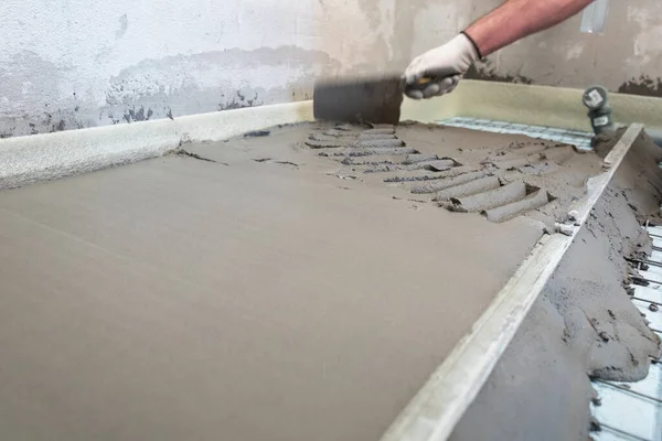 Construction worker performs floor screed indoors. Leveling the floor. — Stock Photo, Image