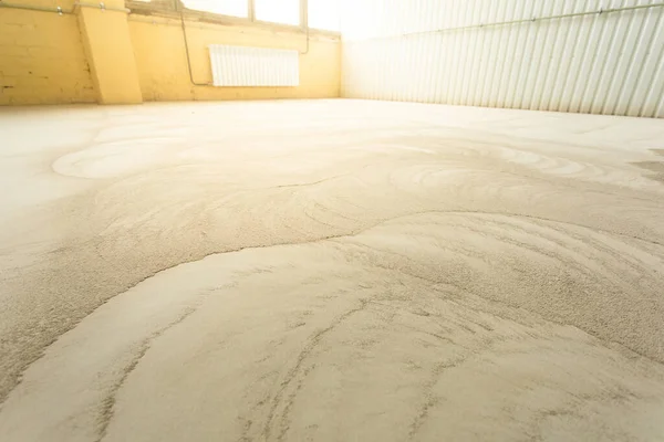 Concrete floor grinding. Construction process. Sanding a concrete floor with a sander in a warehouse