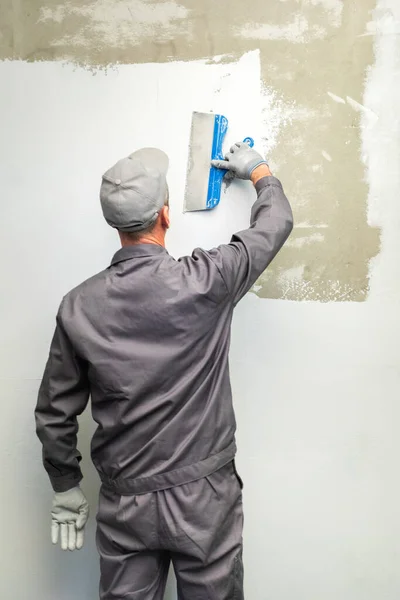 Applying waterproofing mastic to the wall with a wide spatula. — Stock Photo, Image