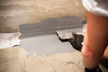 Applying a waterproofing tape to the joint between the wall and the floor. Internal construction works clipart