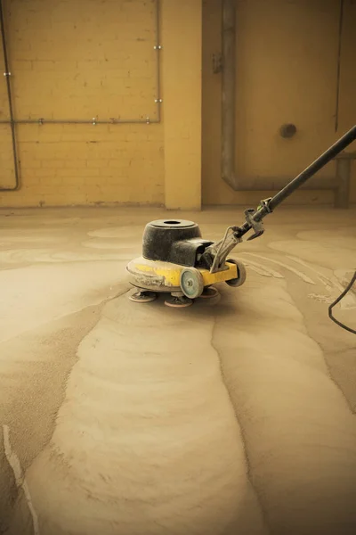 Betonboden schleifen. Bauprozess. Schleifen eines Betonbodens mit einem Schleifer in einer Lagerhalle — Stockfoto