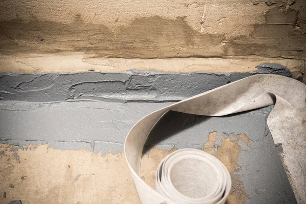 Applying a waterproofing tape to the joint between the wall and the floor. Internal construction works — Stock Photo, Image