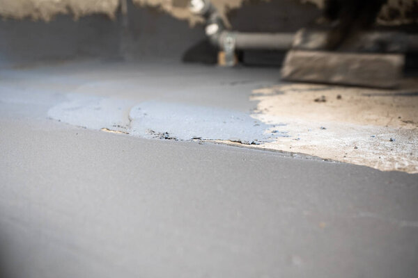 Свеженанесенный гидроизоляционный раствор на пол внутри здания. Внутреннее строительство.