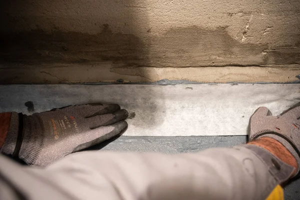 Aplicando uma fita de impermeabilização para a articulação entre a parede e o chão. Obras de construção interna — Fotografia de Stock