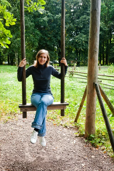 Young woman swinging on the swings — Stock Photo, Image