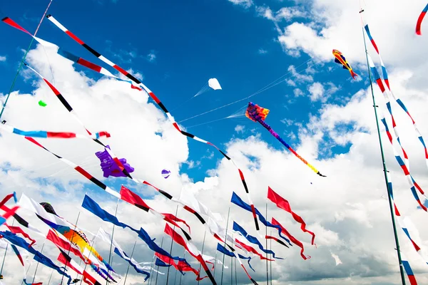 Várias bandeiras e pipas voando no céu azul — Fotografia de Stock