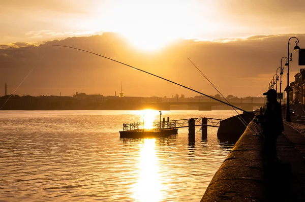 Silhouet van fisher met de wensen van de staaf aan de oever van de rivier de Neva — Stockfoto