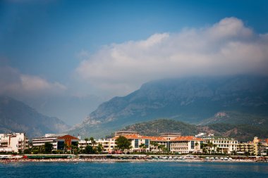 Coastline with hotels in Kemer and mountain behind clipart