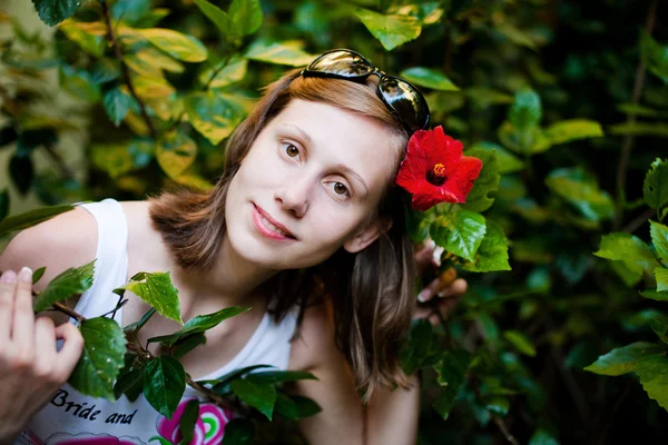 Beautiful woman in the garden with flower — Stock Photo, Image