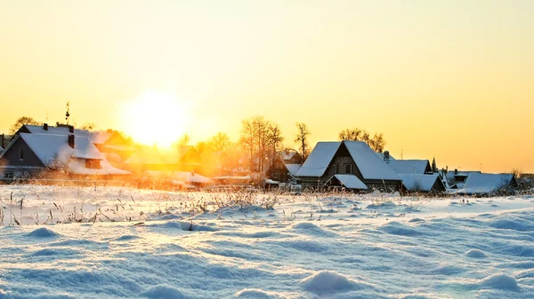 Besneeuwde dorp in zonsondergang — Stockfoto