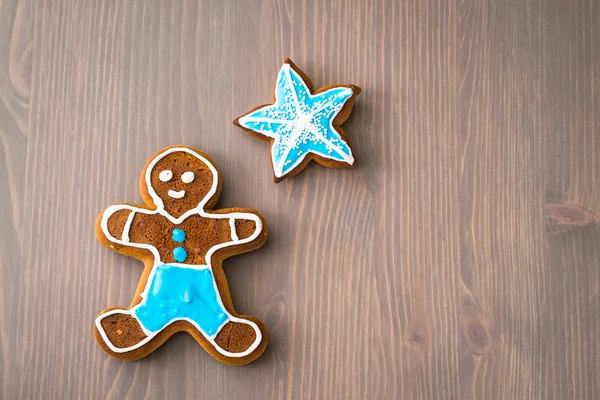 Gingerbread man and star on wooden table — Stock Photo, Image