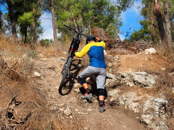 Bir Dağ Bisikletçisi Elinde Bisikletle Yamaca Tırmanıyor — Stok fotoğraf