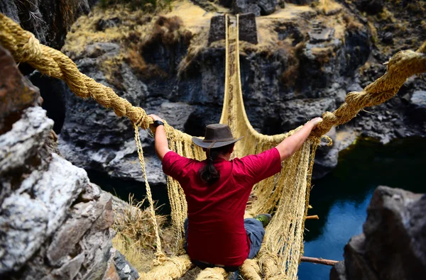 Viajante em uma ponte de corda perigosa — Fotografia de Stock