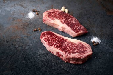 Kaliteli mermer Japon Wagyu bifteği koyu taşlı arka planda, taze New York bifteği.